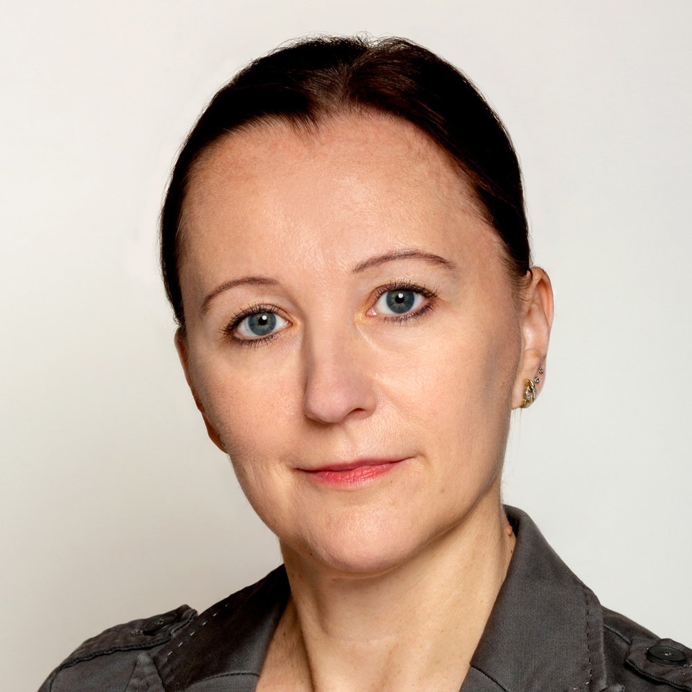 Portrait Prof. Dr. Doris Decker, weiblich lesbare, hellhäutige Person mit grauem Blazer und zusammengebundenen, dunkelbraunen Haaren