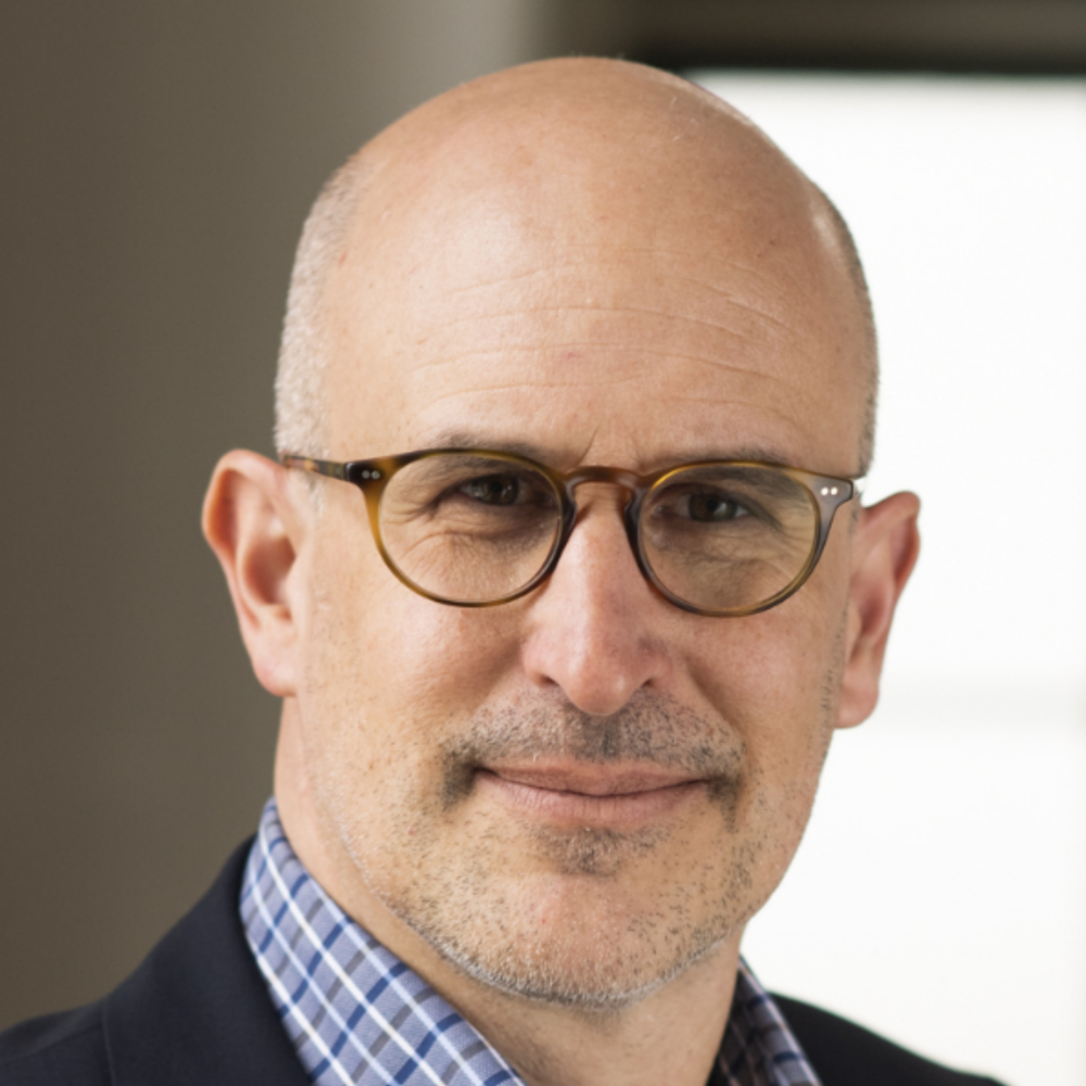 Portrait Prof. Dr. Matthias D. Wüthrich, männlich lesbare, hellhäutige Person mit blau-karriertem Hemd, schwarzem Sacko, Brille, Glaze
