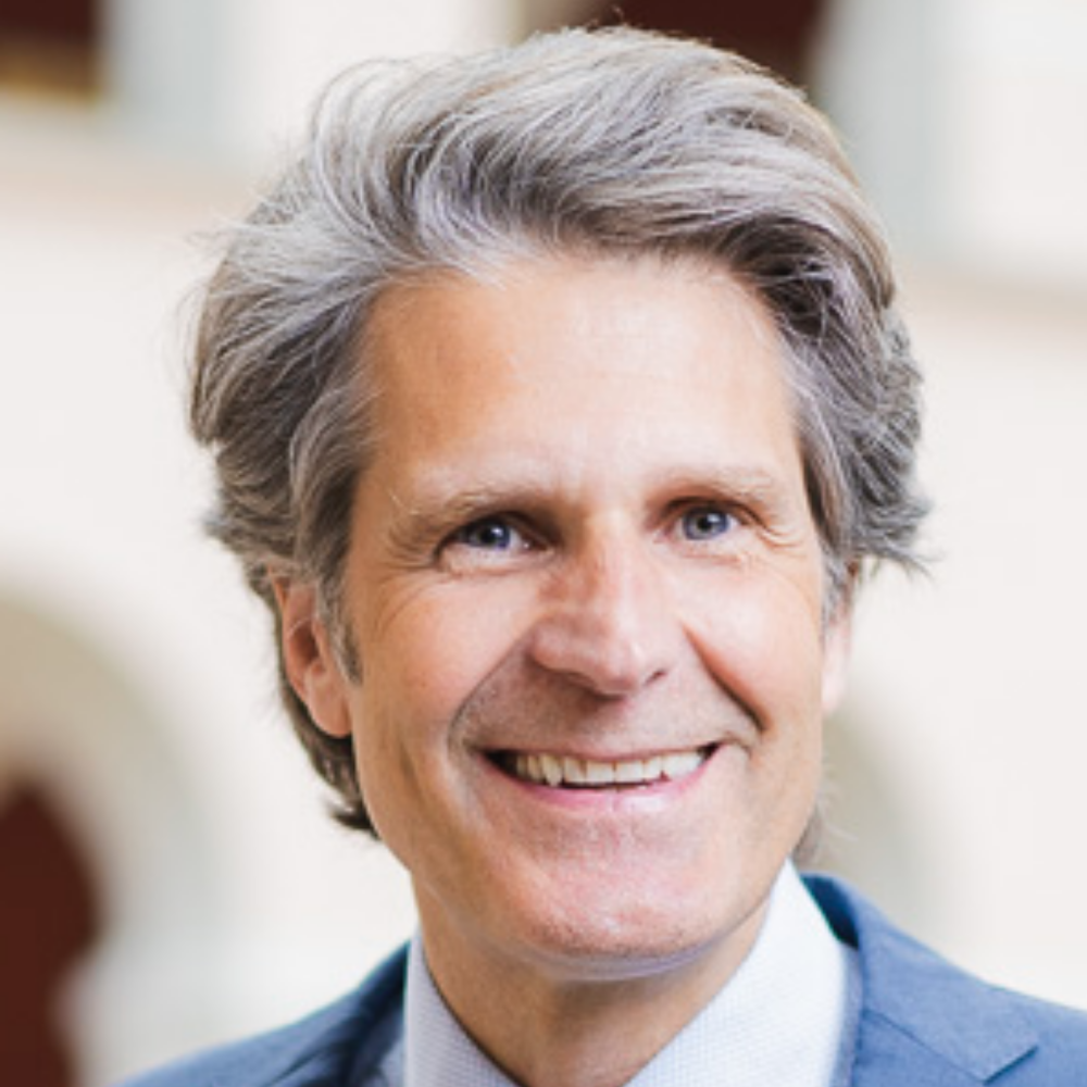 Portrait Prof. Dr. David Seidl, männlich lesbare, hellhäutige Person mit grauen Haaren, weissem Hemd und blauem Sakko